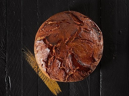 Der Wilhelm der Bäckerei Pappert wird nach Opa Wilhelm's alter Rezeptur auf Stein gebacken Der Wilhelm der Bäckerei Pappert auf einem schwarzem Holzhintergrund platziert.