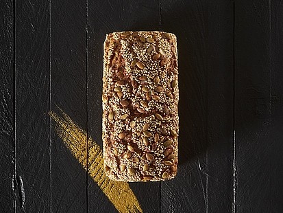Der Roggen-Dinkler der Bäckerei Pappert zeichnet sich durch eine saftige Krume und lange Verzehrfrische aus Der Roggen-Dinkler der Bäckerei Pappert auf einem schwarzem Holzhintergrund platziert.