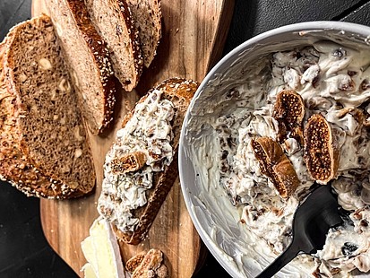 Der Feigen-Frischkäse-Aufstrich in einer Schale neben dem Nussbrot platziert.
