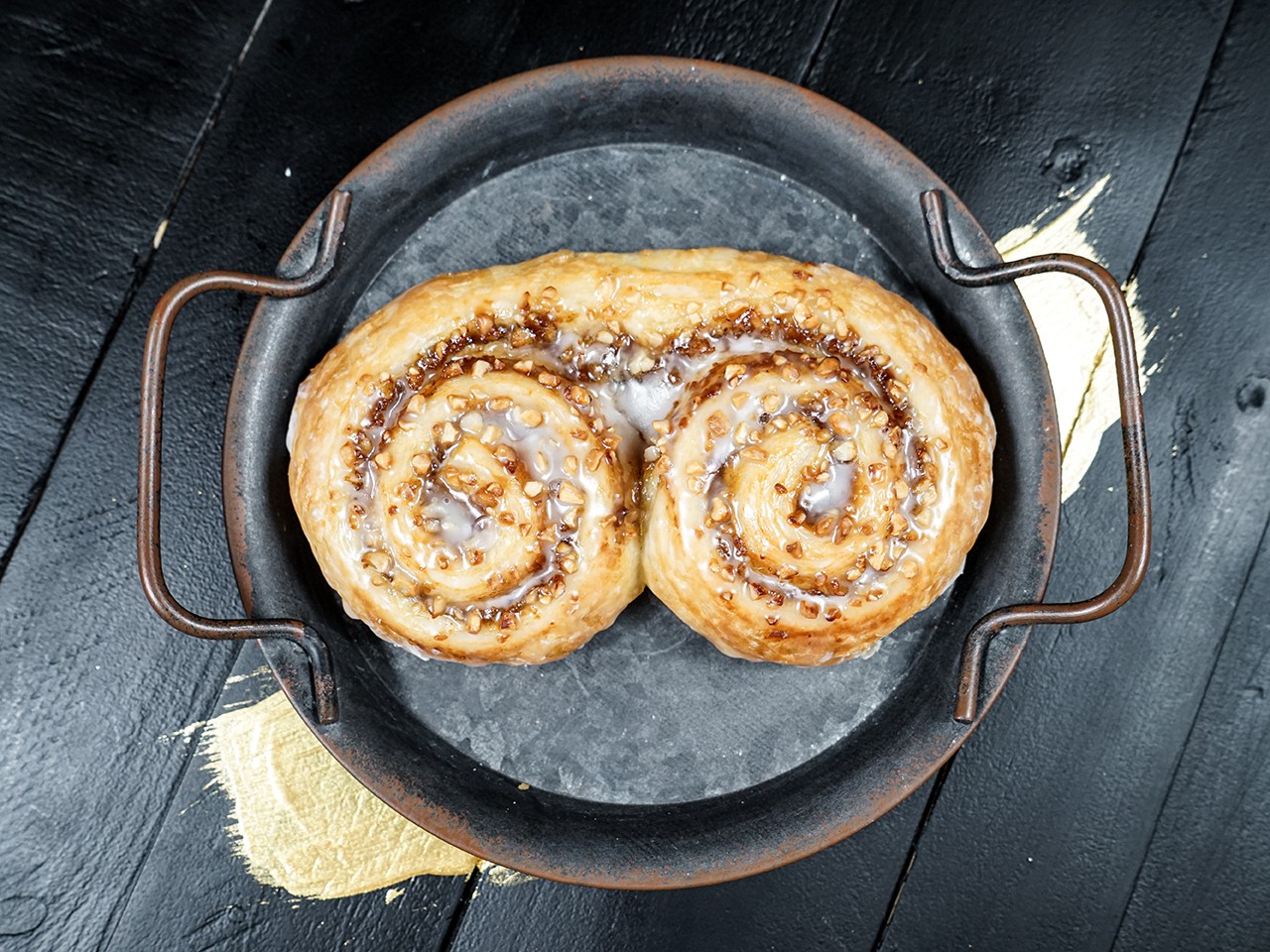 Das Nussglück der Bäckerei Pappert platziert in einer edlen Pfanne auf dunklem Holzhintergrund.
